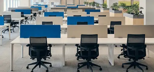 Modern open-plan office space featuring clean workstations, ergonomic chairs, and sanitized carpets provided by professional office cleaning services in New Haven, CT.